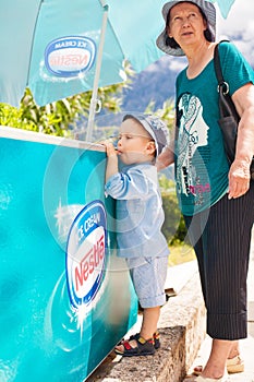 Boy and grandmother near the fridge with ice cream